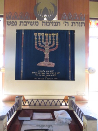 Die Menora auf dem Vorhang vor dem Toraschrein der Synagoge in Schilo